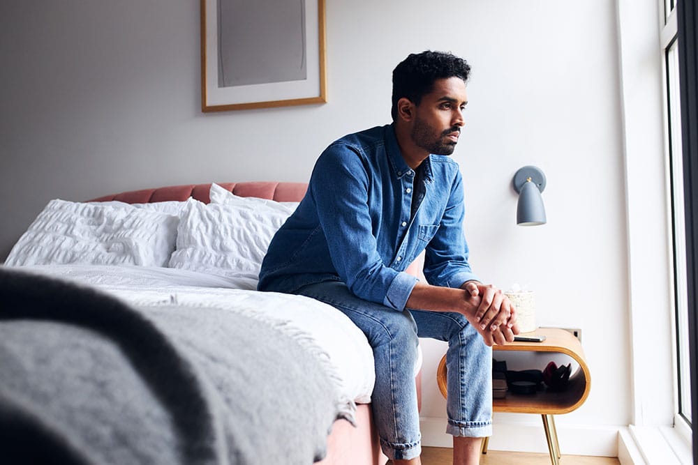 Anxiety-02.24 Man sat on bed feeling anxious