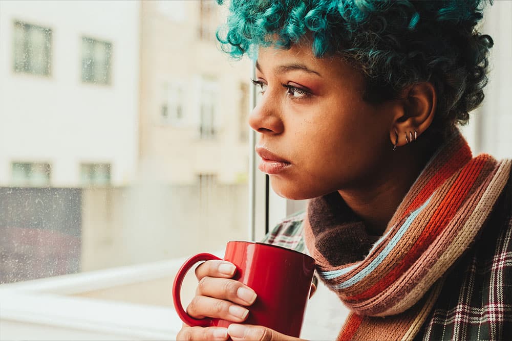 Seasonal affective disorder Female looking out the window deep in thought.