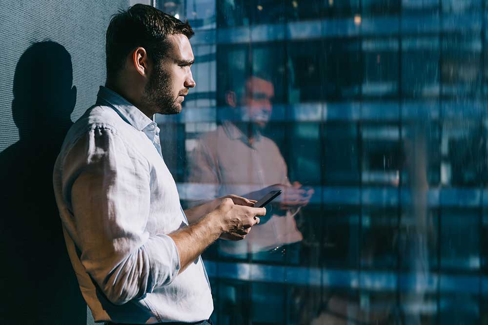 Male employee deep in thought looking out of window