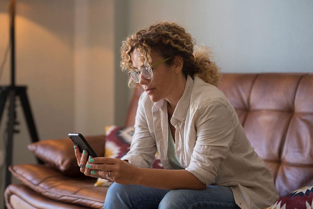 Person researching on their phone to find out ways to reduce their cancer risk