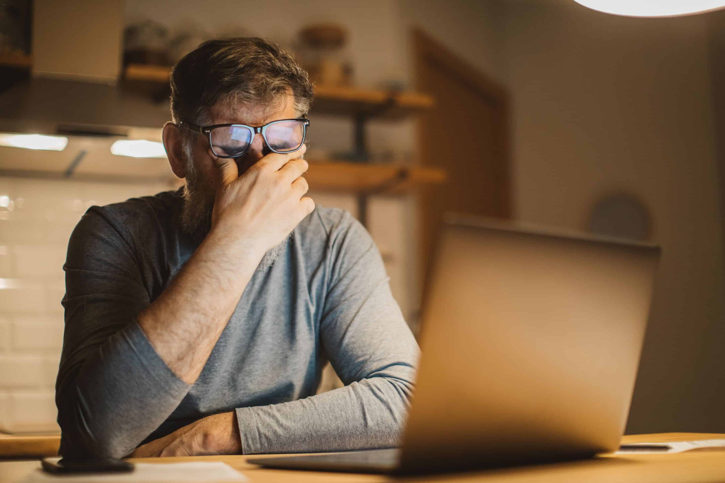 Man rubbing his eyes as tired and stressed